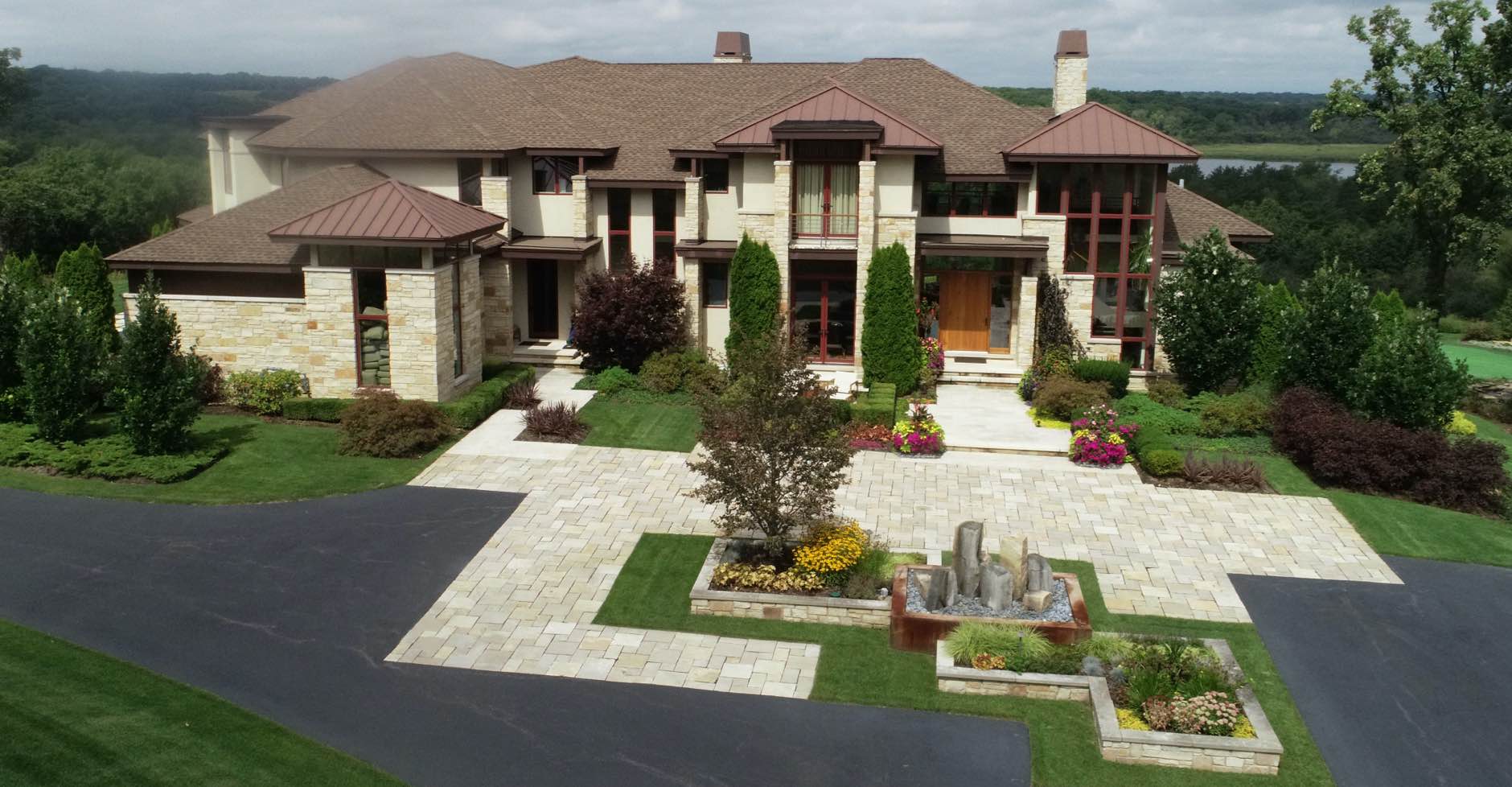 High-angle view of front of home with recticlinear pavers and plantings