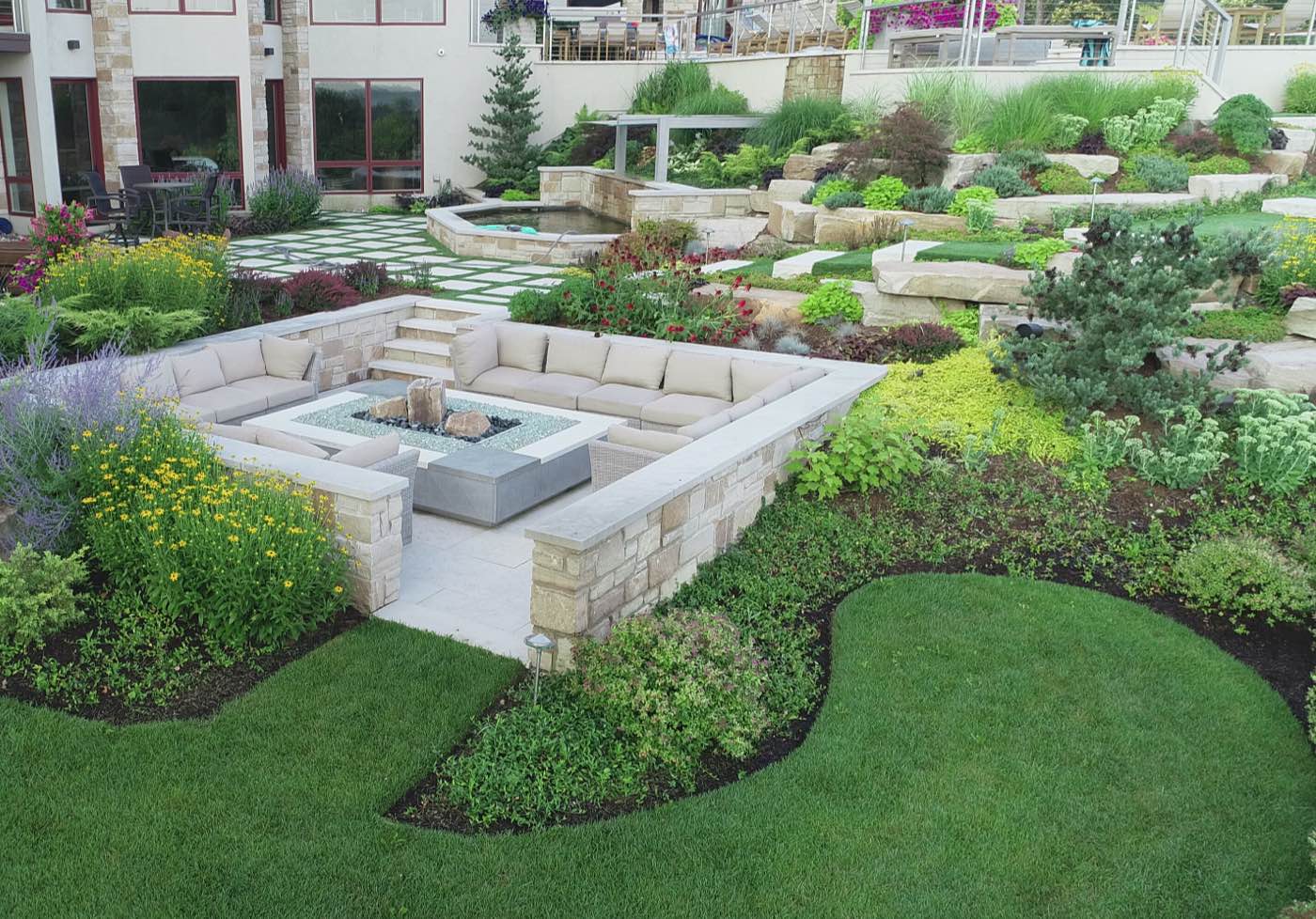 Outdoor seating area with fountain and raised plantings in background